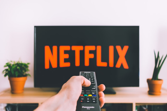 TV remote pointing at a screen showing Netflix